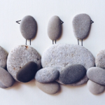 Photo of beach rocks arranged as birds on shore